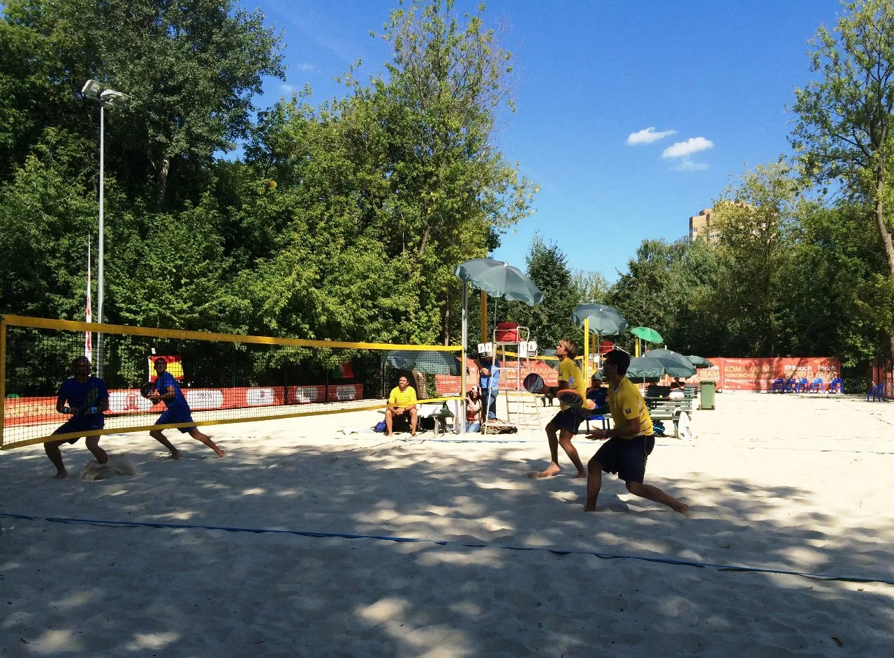 Jugadores de beach tennis disputando un encuentro en arena.